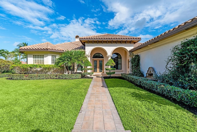 mediterranean / spanish home featuring a front yard and french doors