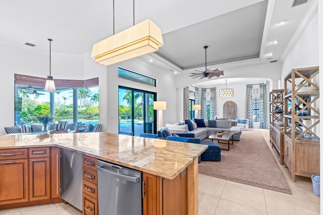 kitchen with light stone counters, a raised ceiling, ceiling fan, light tile patterned floors, and hanging light fixtures