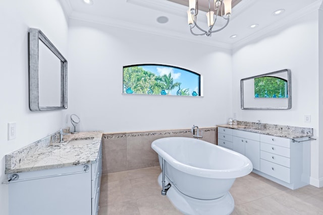 bathroom featuring a bathing tub, vanity, ornamental molding, and tile patterned floors