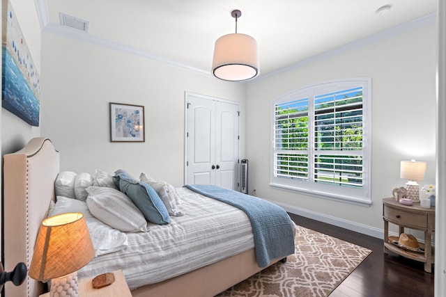 bedroom featuring crown molding, a closet, and dark wood-type flooring