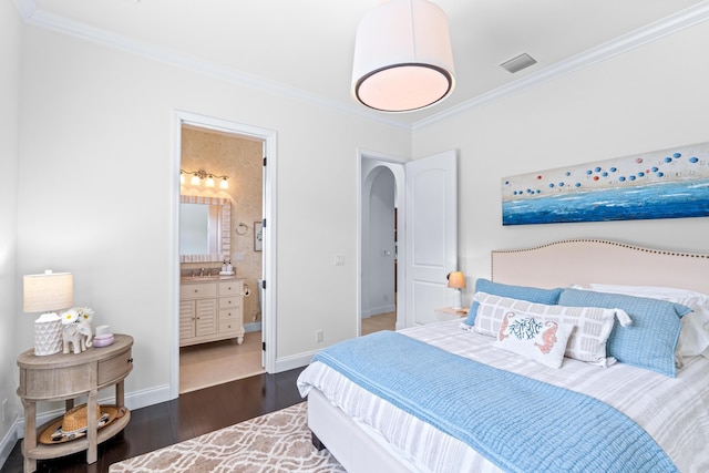 bedroom with dark hardwood / wood-style flooring, ensuite bathroom, and ornamental molding