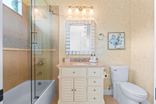 full bathroom with tile patterned floors, toilet, vanity, and combined bath / shower with glass door