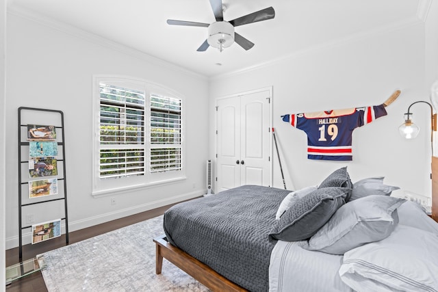 bedroom with dark hardwood / wood-style flooring, a closet, ceiling fan, and ornamental molding