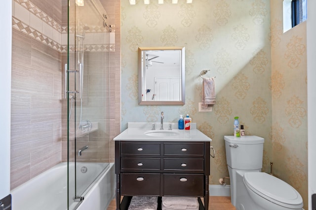 full bathroom featuring toilet, combined bath / shower with glass door, and vanity