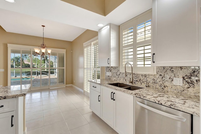 kitchen with light stone counters, a sink, white cabinetry, backsplash, and dishwasher