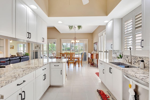 kitchen featuring light tile patterned flooring, sink, white cabinetry, stainless steel dishwasher, and pendant lighting