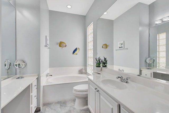 bathroom with tile patterned flooring, vanity, toilet, and a tub to relax in