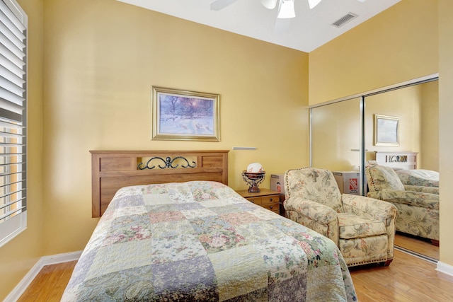 bedroom featuring ceiling fan, light hardwood / wood-style floors, and a closet