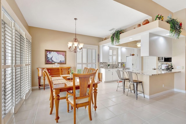 dining area with ceiling fan with notable chandelier and light tile patterned flooring