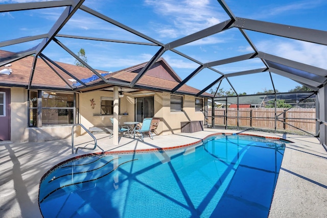 view of pool with ceiling fan, a lanai, and a patio