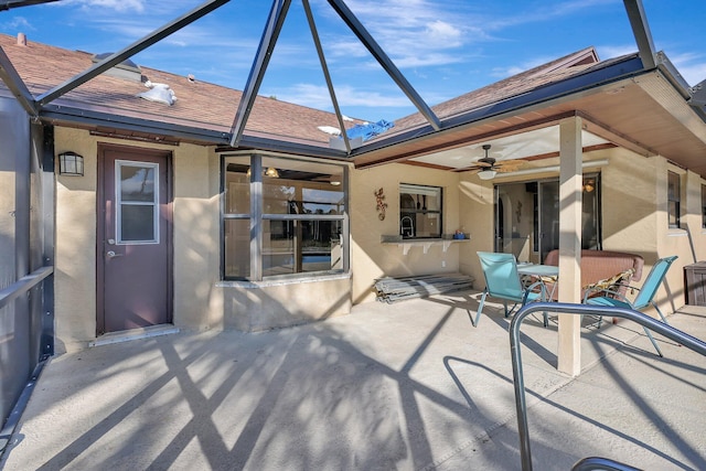 back of property with a patio, glass enclosure, and ceiling fan