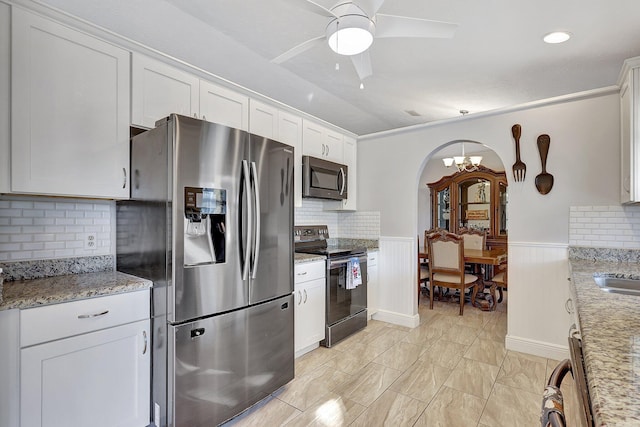 kitchen featuring ceiling fan, light stone counters, backsplash, white cabinets, and appliances with stainless steel finishes