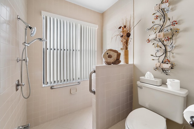 bathroom featuring tiled shower, tile patterned flooring, tile walls, and toilet