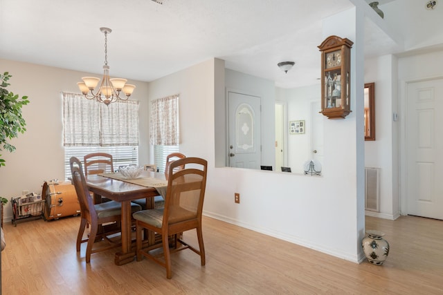 dining space featuring a chandelier and light wood-type flooring