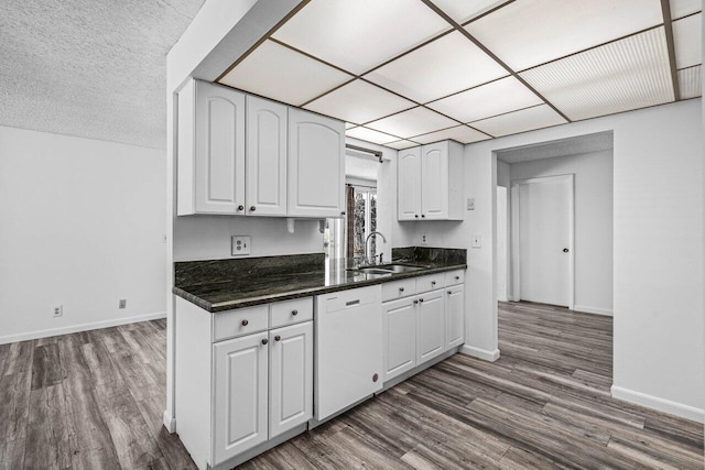 kitchen with a paneled ceiling, dishwasher, sink, dark hardwood / wood-style floors, and white cabinetry