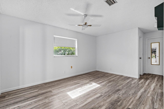 spare room featuring ceiling fan, a textured ceiling, and light hardwood / wood-style flooring