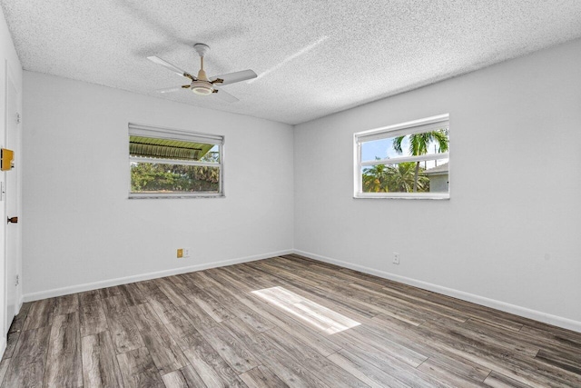 empty room with ceiling fan, hardwood / wood-style floors, and a textured ceiling