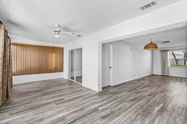 unfurnished room with hardwood / wood-style floors, a textured ceiling, and ceiling fan