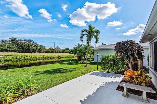 view of yard featuring a water view and a patio area