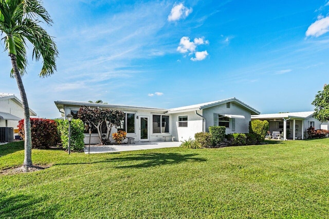 rear view of property featuring central AC and a lawn