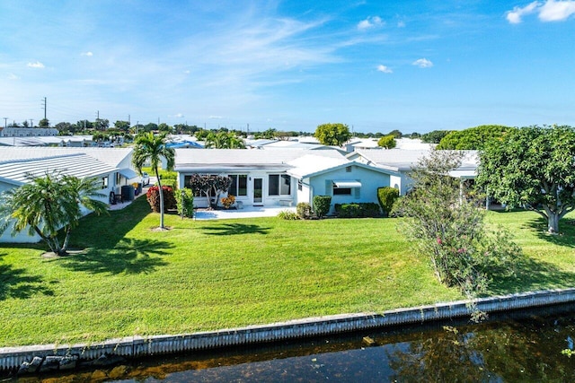 rear view of property with a water view and a yard