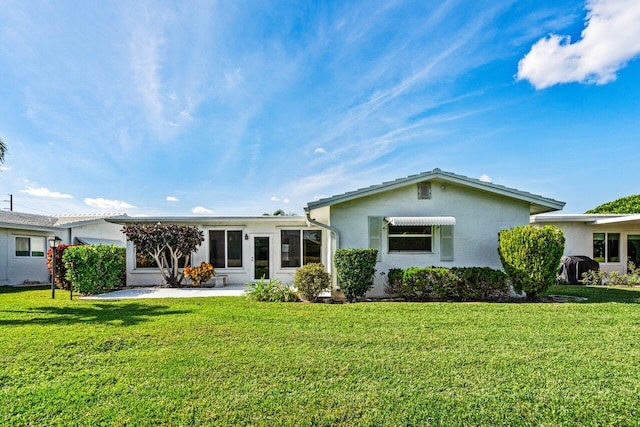 rear view of house featuring a lawn