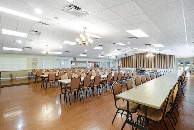 dining area featuring a chandelier and a drop ceiling