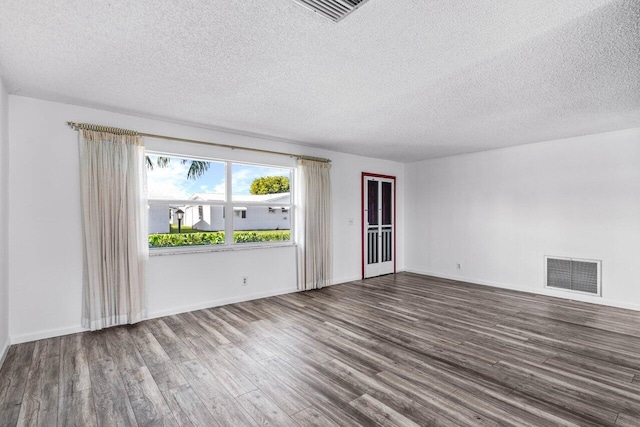 unfurnished room featuring wood-type flooring and a textured ceiling