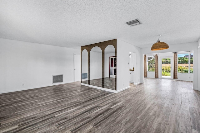 unfurnished living room featuring a textured ceiling and dark wood-type flooring