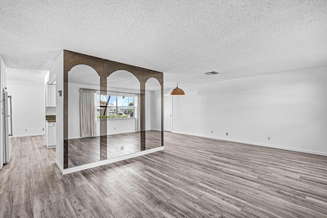 empty room featuring a textured ceiling and light wood-type flooring