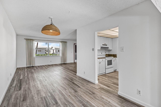 unfurnished living room featuring light hardwood / wood-style floors and a textured ceiling