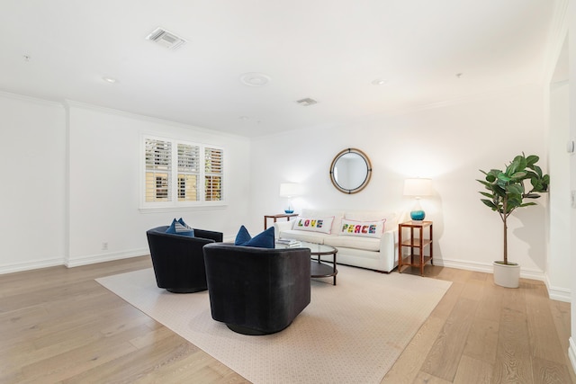 living room with light hardwood / wood-style flooring and crown molding