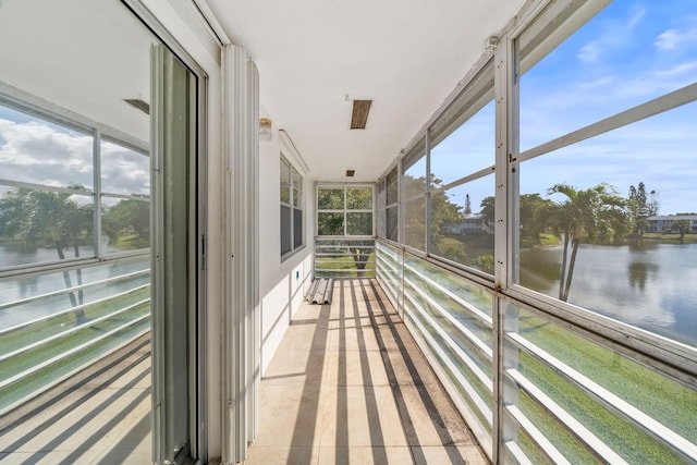 unfurnished sunroom featuring a water view and a wealth of natural light