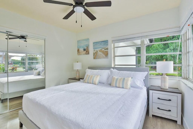 bedroom with a closet, multiple windows, ceiling fan, and light hardwood / wood-style flooring