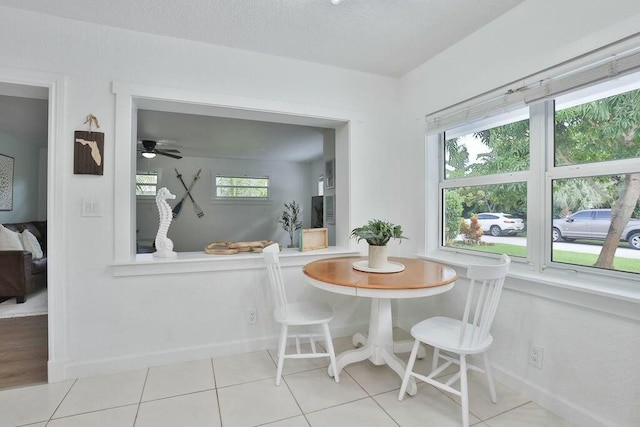 dining area with light tile patterned floors, breakfast area, a textured ceiling, and ceiling fan