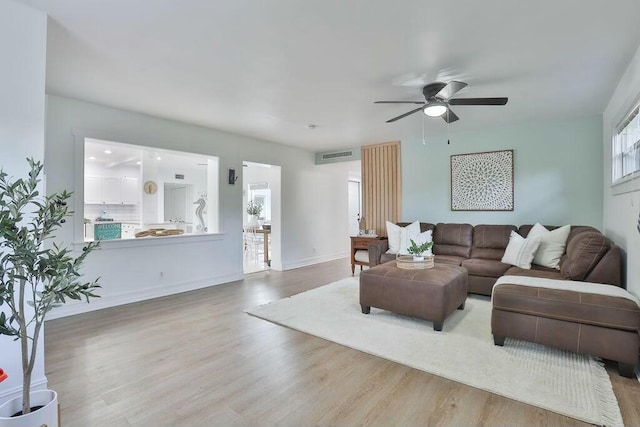 living room with light hardwood / wood-style floors and ceiling fan