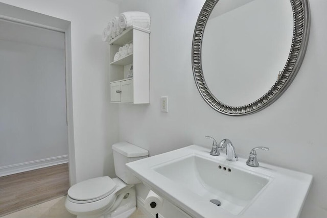 bathroom with toilet, sink, and hardwood / wood-style flooring