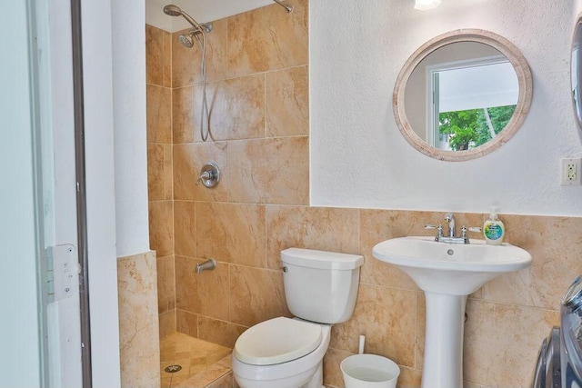 bathroom featuring toilet, tile walls, and tiled shower