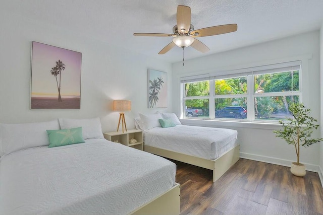 bedroom with ceiling fan, dark wood-type flooring, and multiple windows