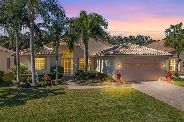 mediterranean / spanish house featuring a yard and a garage