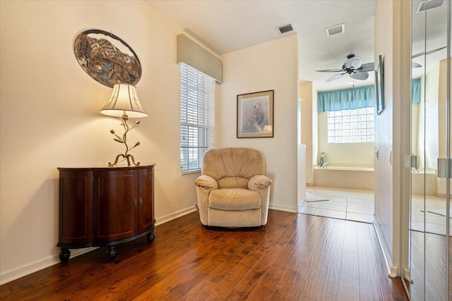 living area with ceiling fan and dark wood-type flooring