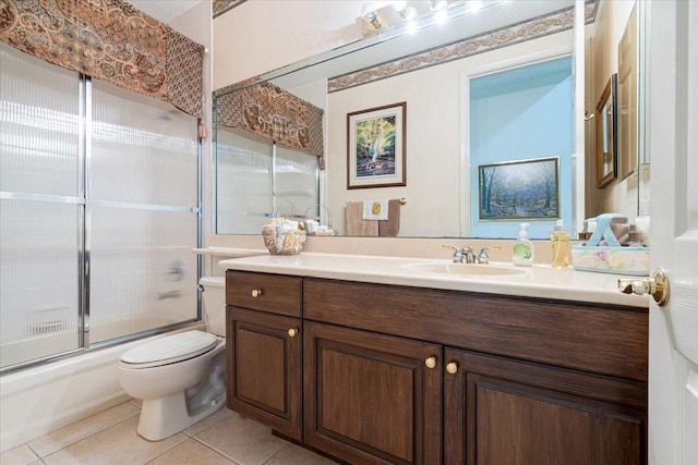 full bathroom featuring toilet, tile patterned flooring, vanity, and combined bath / shower with glass door