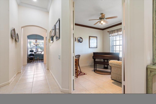 hall with light tile patterned floors, a healthy amount of sunlight, and ornamental molding