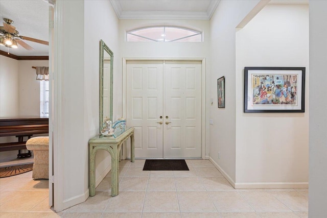 tiled entryway with ceiling fan, plenty of natural light, and ornamental molding