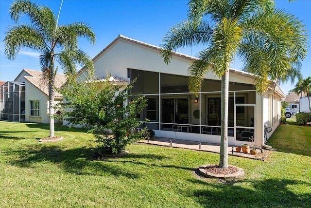 rear view of property featuring a lawn and a sunroom