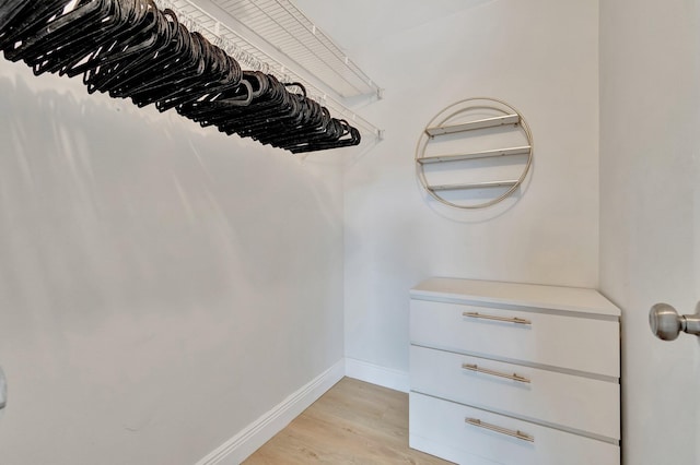 walk in closet with light hardwood / wood-style flooring