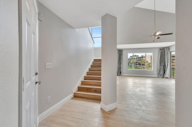 stairs featuring hardwood / wood-style flooring and ceiling fan