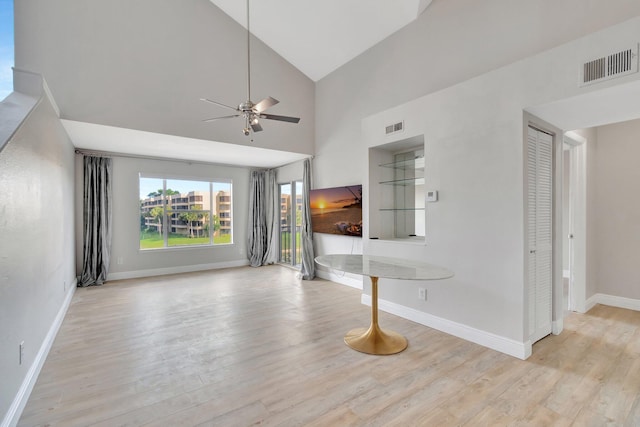 unfurnished living room featuring ceiling fan, high vaulted ceiling, and light hardwood / wood-style flooring