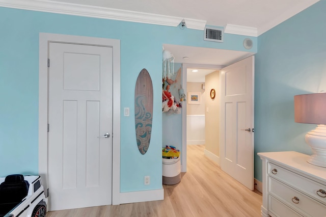 bedroom featuring ornamental molding and light hardwood / wood-style flooring