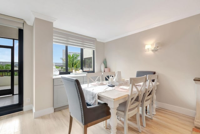 dining area with crown molding and light hardwood / wood-style flooring